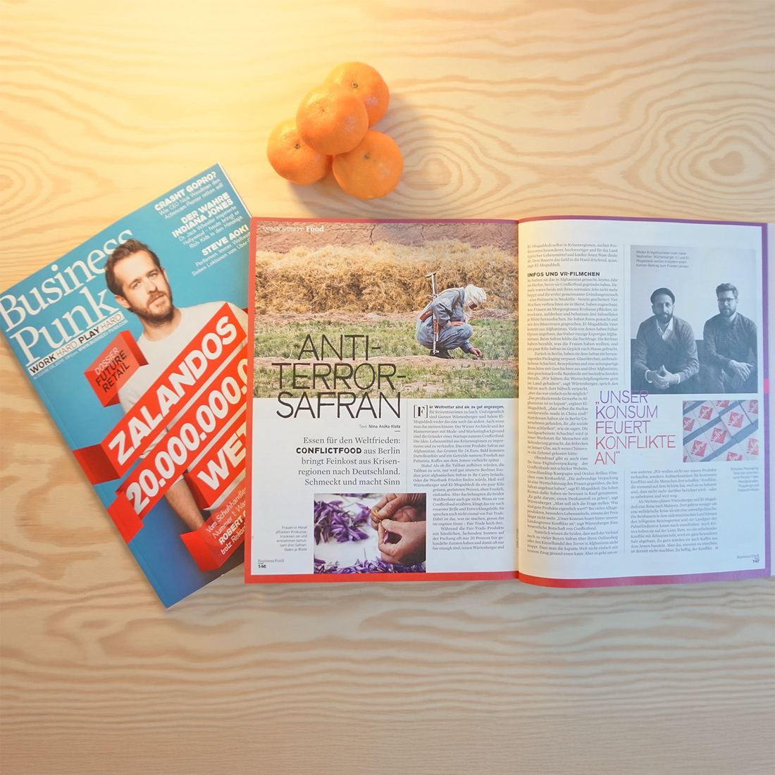 Die Zeitschrift Business Punk liegt aufgeschlagen und ein Berg Orangen liegt daneben