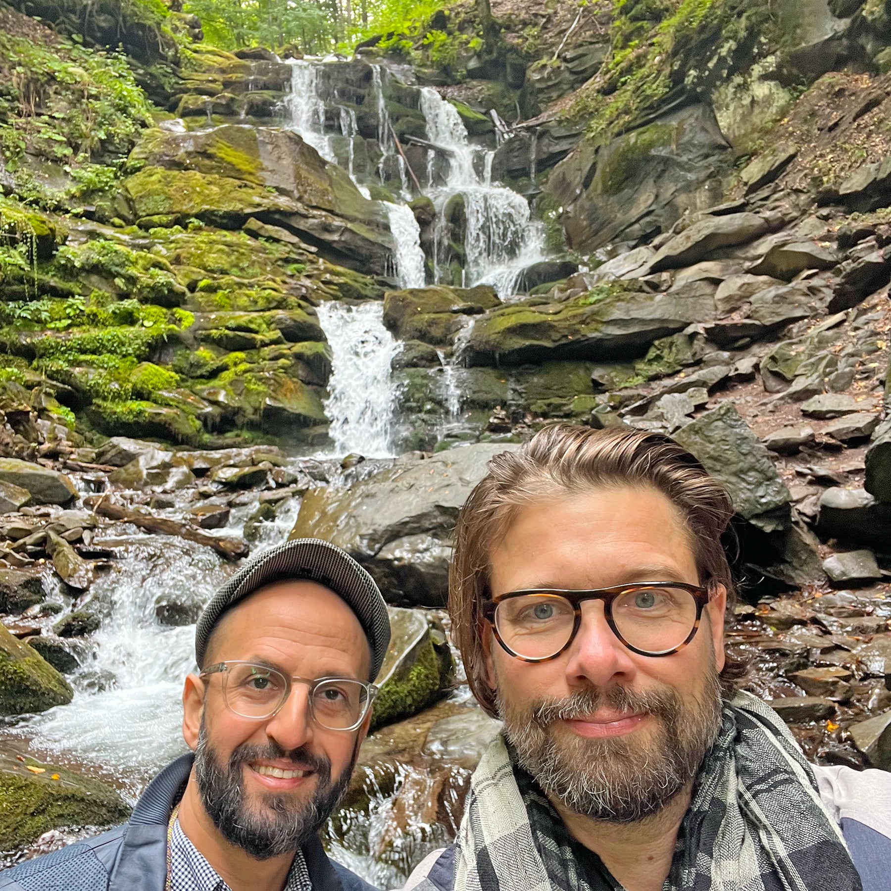 Salem El-Mogaddedi und Gernot Würtenberger von Conflictfood stehen vor einem Wasserfall im Naturschutzgebiet der Karpaten in der Ukraine