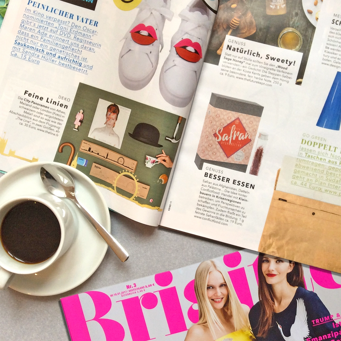 Die Zeitschrift Brigitte liegt aufgeschlagen und eine Tasse Kaffee steht daneben