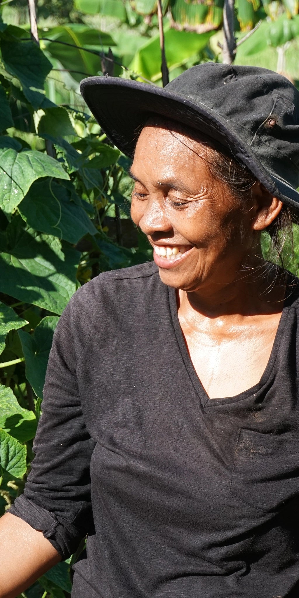 Eine Frau in Kambodscha steht vor einer Kampot Pfeffer Pflanze