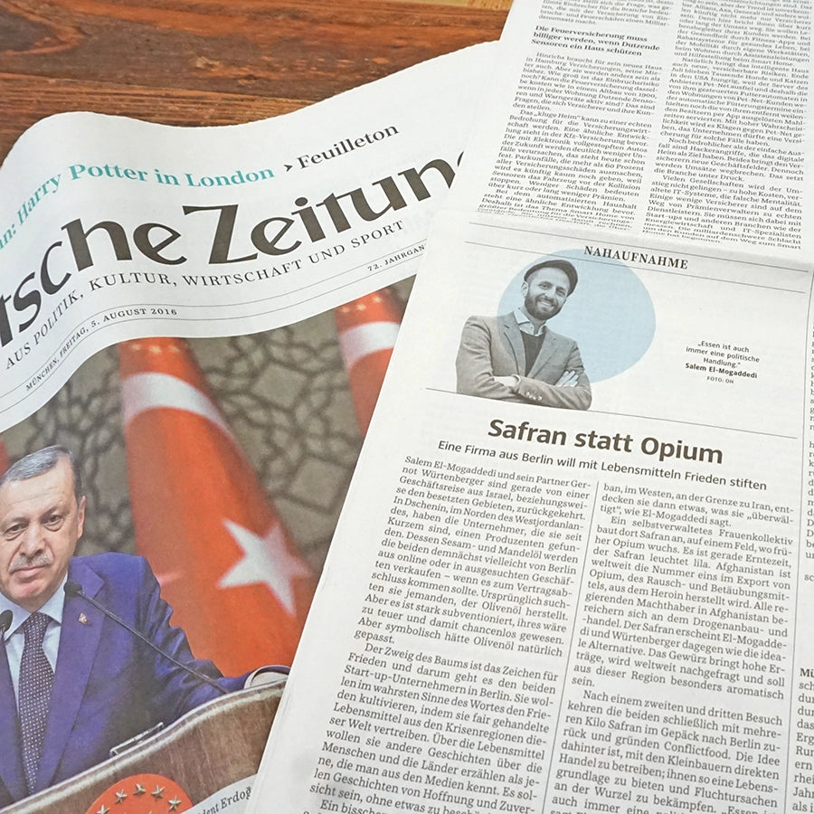 Die Zeitung Süddeutsche Zeitung SZ liegt auffgeschlagen auf einem Tisch und zeigt den Artikel Safran Statt Opium