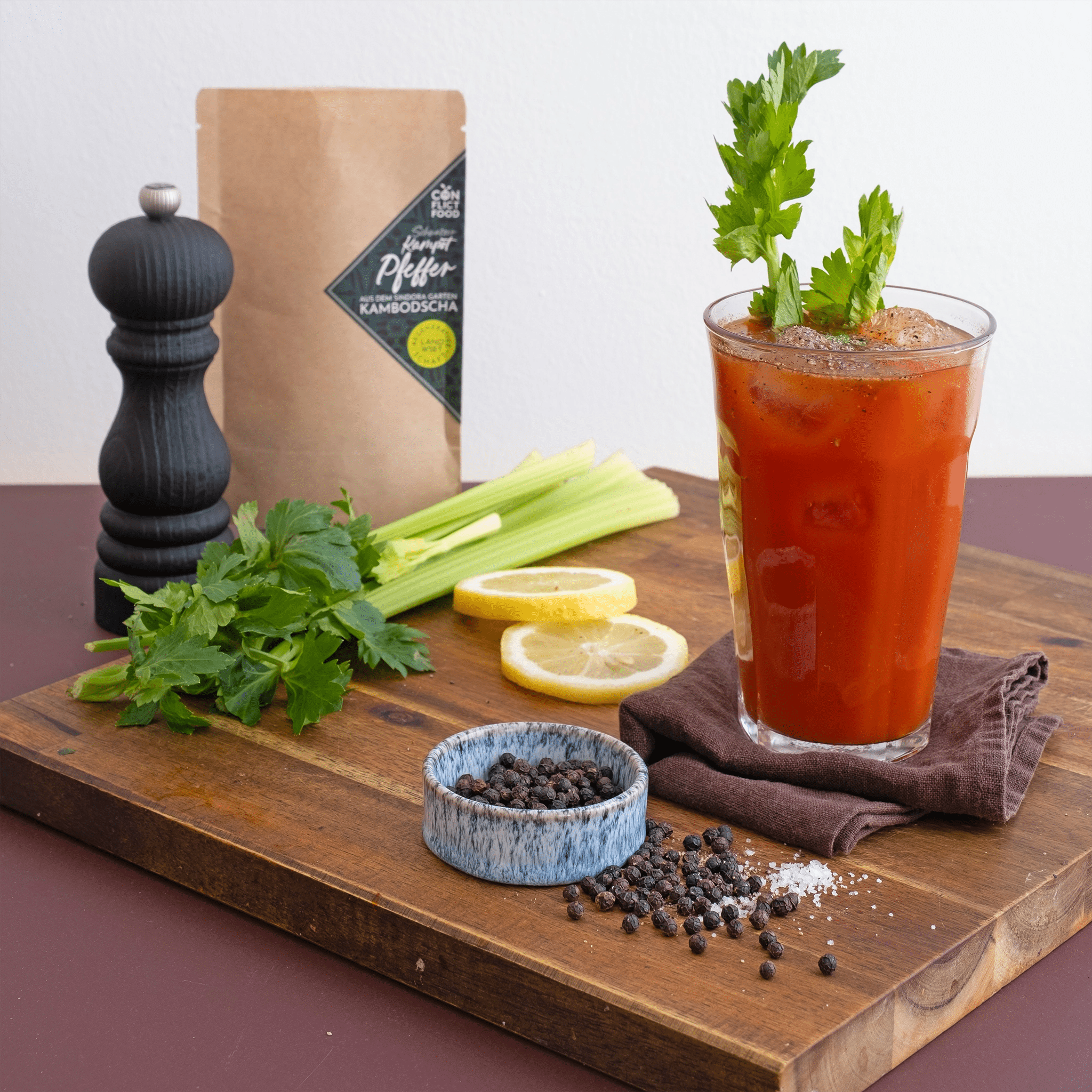 Ein Gals mit Bloody Marry neben Kampot Pfeffer und Stangensellerie