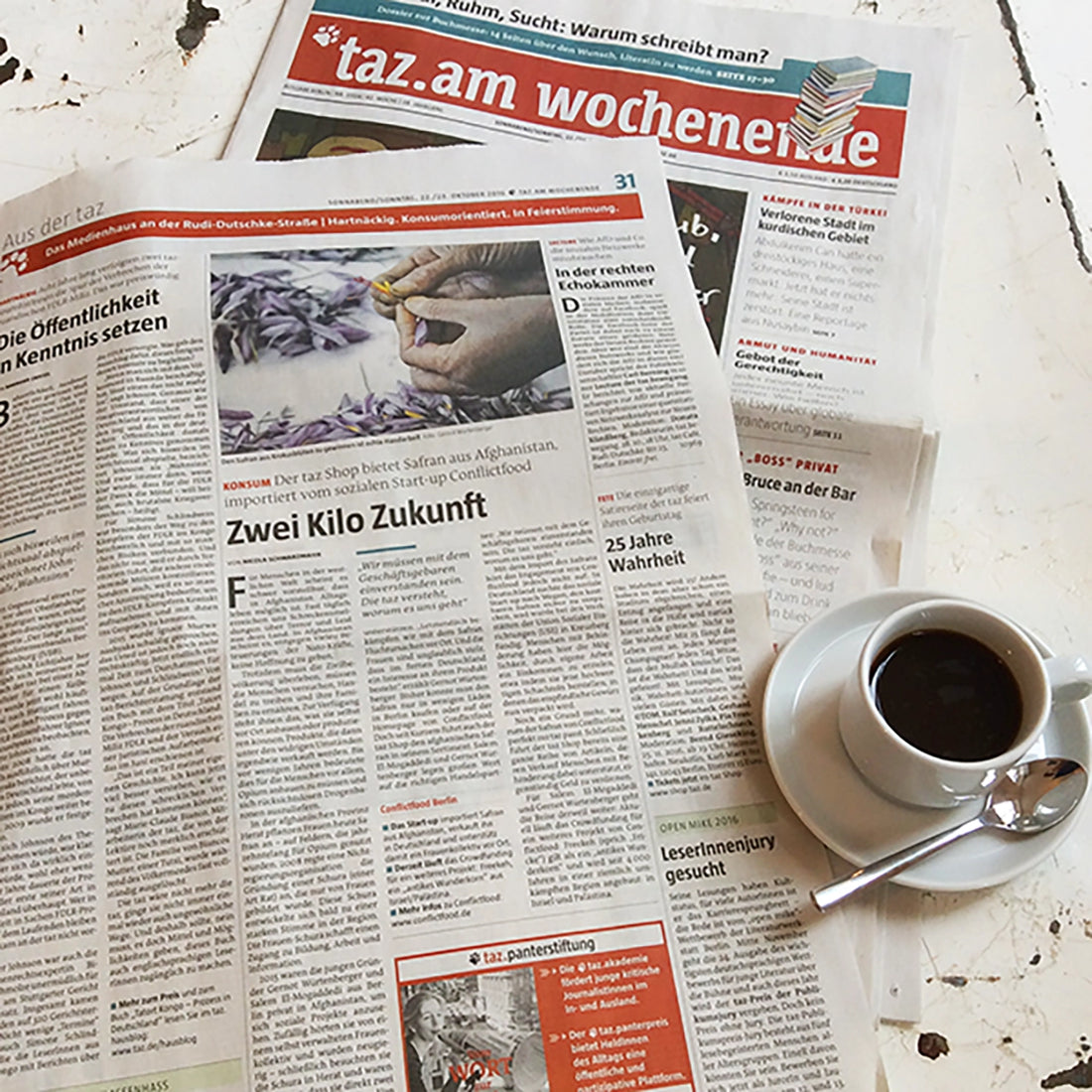 Die aufgeschlagene Tageszeitung taz mit einem umfangreichen Artikel über die Arbeit von Conflictfood sowie eine Tasse Espresso