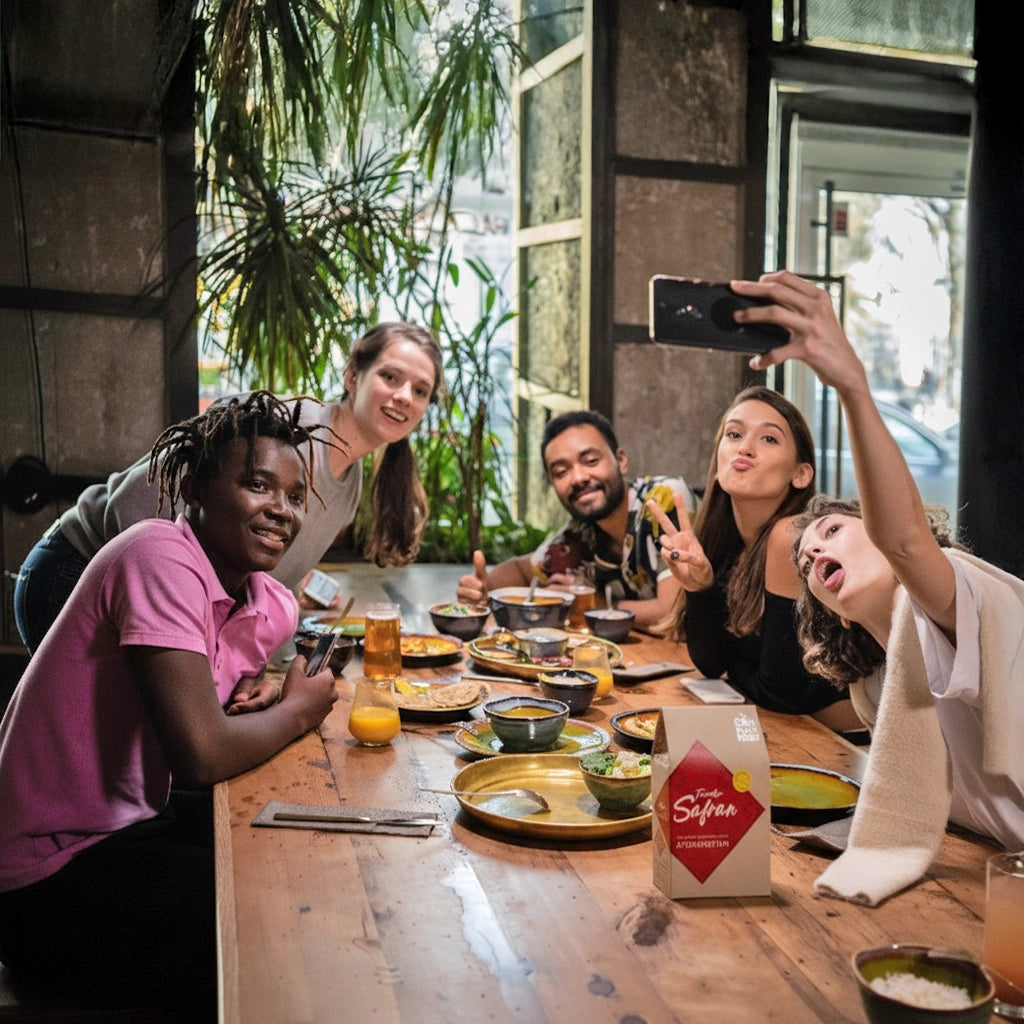 Eine Gruppe von Freunden sitze zusammen am gedeckten Tisch und macht ein Selfie