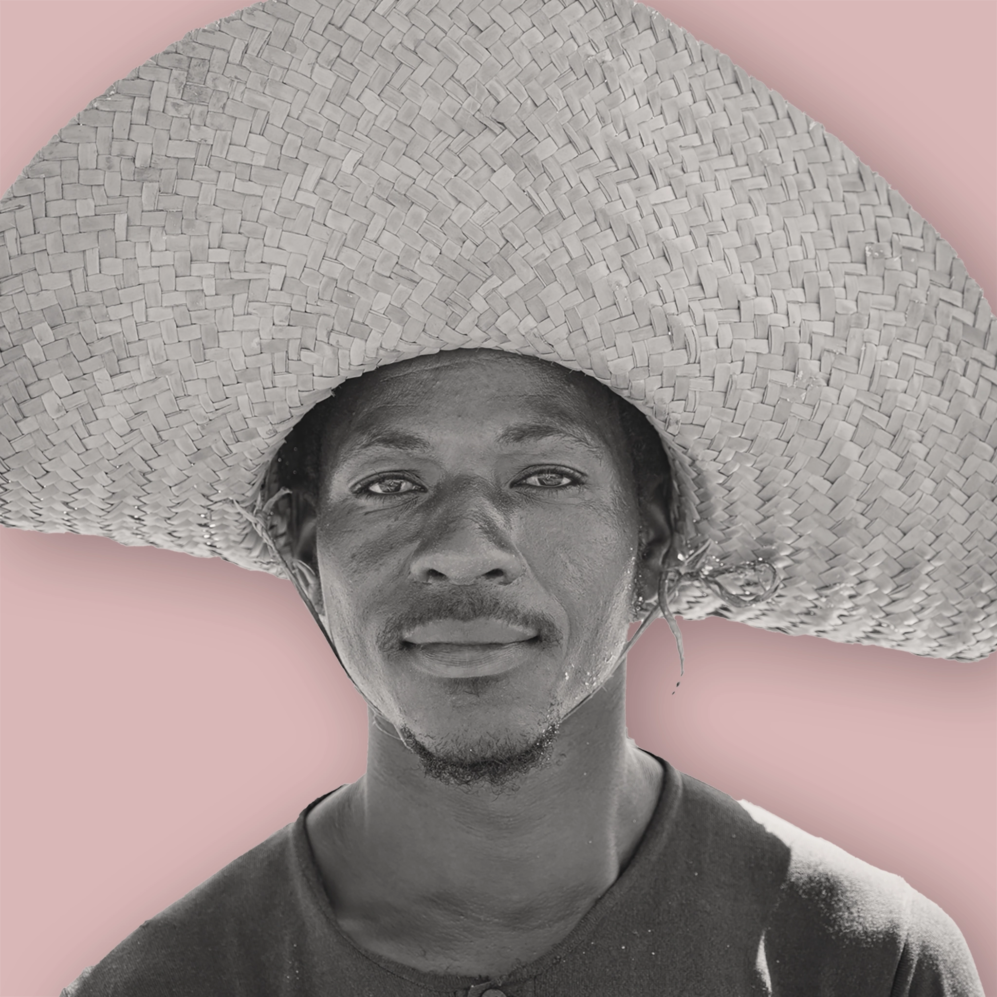 Ein person of color Mann, mit sehr großem Strohhut und Bärtchen.