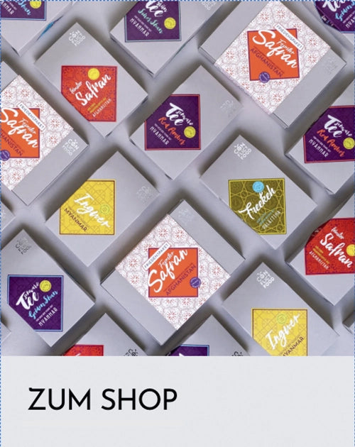 Conflictfood Päckchen liegen aufgereigt auf einem Tisch, darunter liest man: Zum Shop