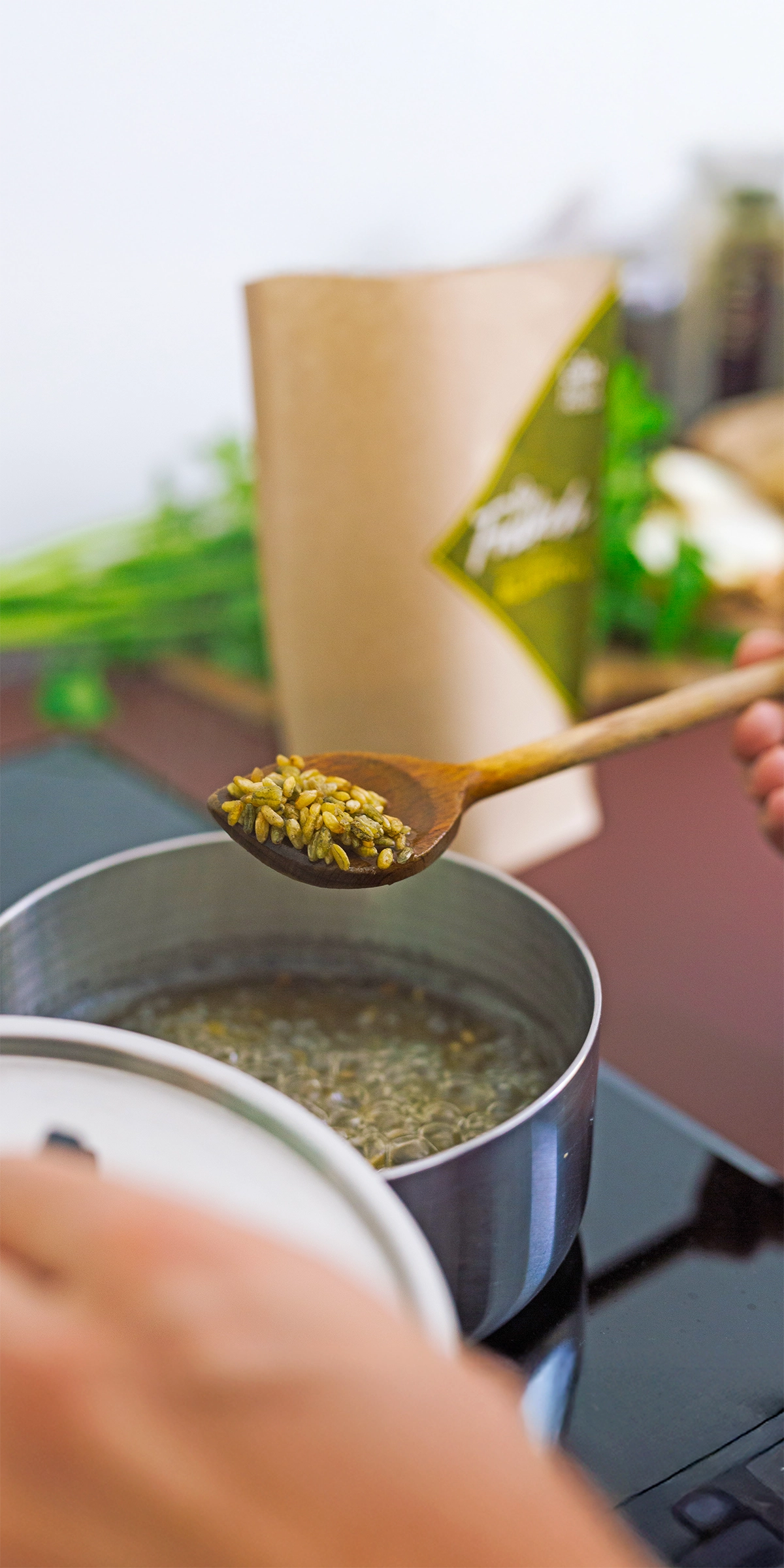 Freekeh kocht in einem Kochtopf und wird mit einem Kochlöffel entnommen
