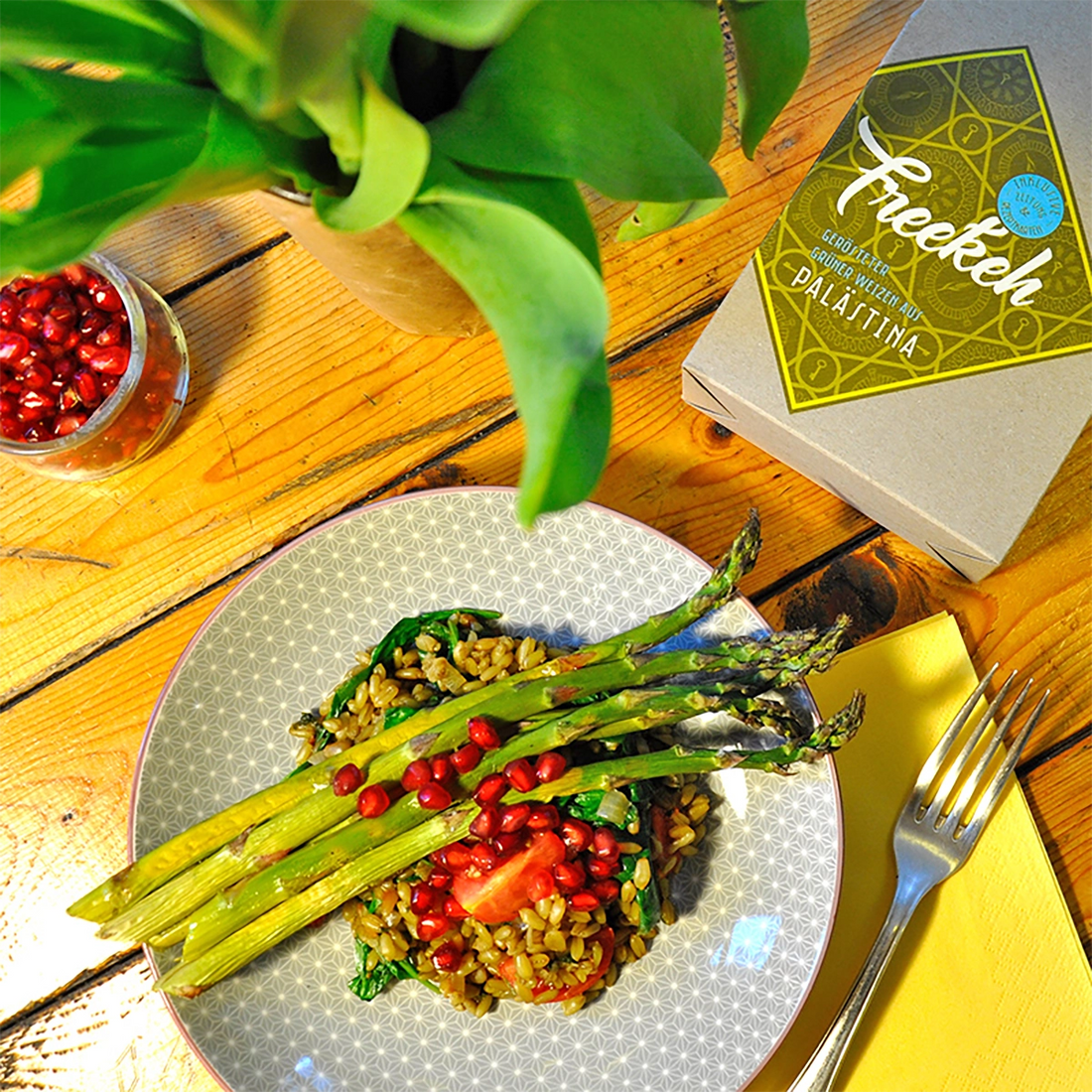 Ein Teller mit Spargel, Freekeh und Dekoration